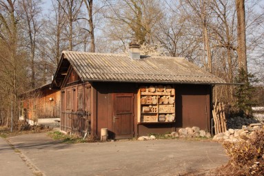 Das Holzgebäude mit seinem grossen Insektenhotel an der Wand.