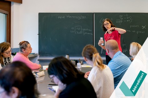 eine Deutschlehrerin unterstützt eine Teilnehmerin beim Lösen einer Aufgabe
