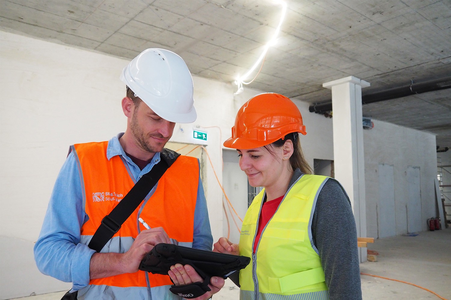 Ein Mitarbeiter der Feuerpolizei füllt auf einer Baustelle eine Checkliste aus. 