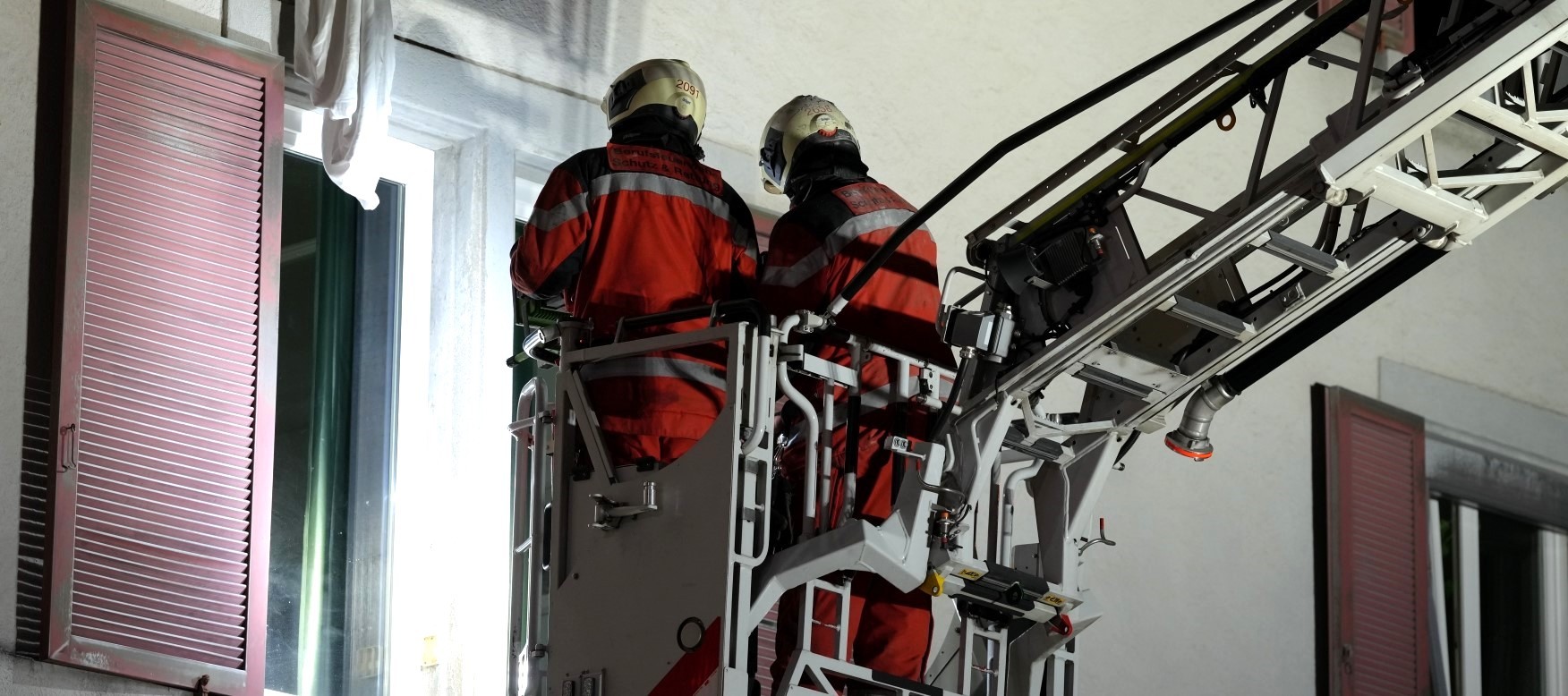 Zwei Feuerwehrleute auf einer Autodrehleiter