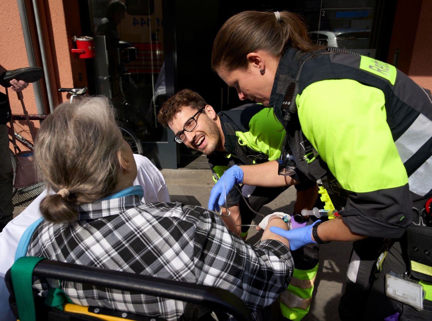 Rettungssanitäter*innen transportieren einen Patienten im Treppenhaus.