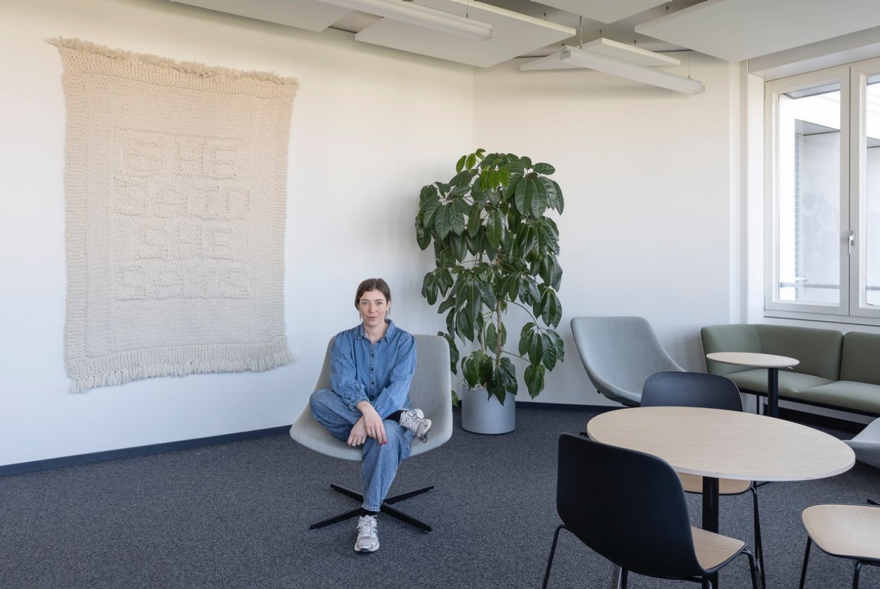 Florence Ritter sitzt vor dem Kunstwerk «she said, she says» von Nicole Bachmann