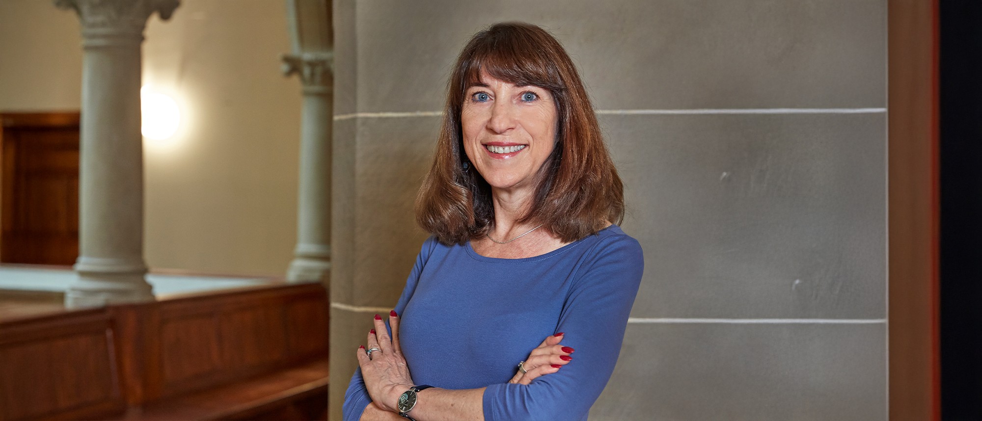 Cristiana Baldauf  lächelnd und mit verschränkten Armen im Stadthaus Zürich