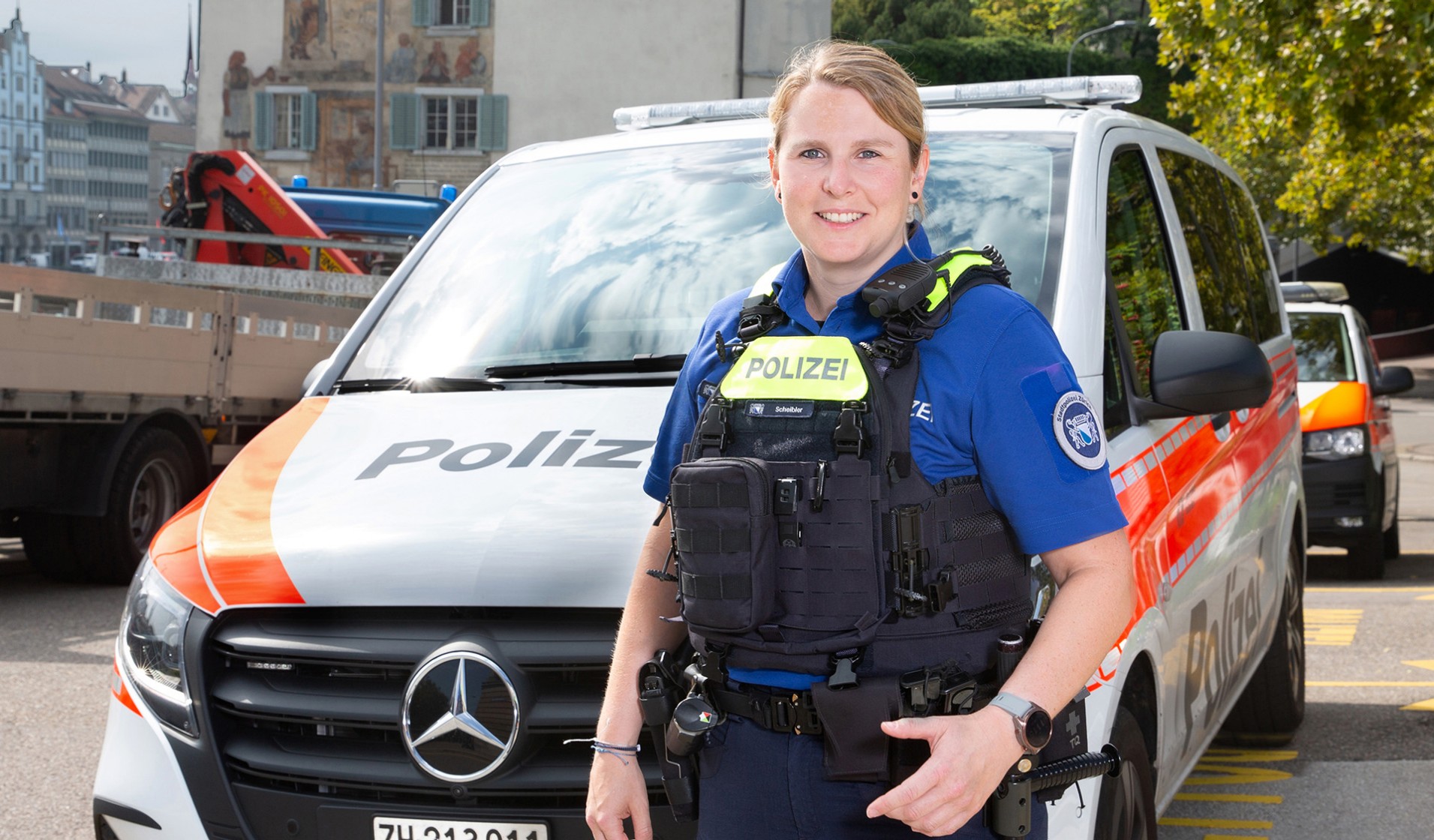 Marina Scheibler in Polizeiunform vor Polizeiauto stehend.