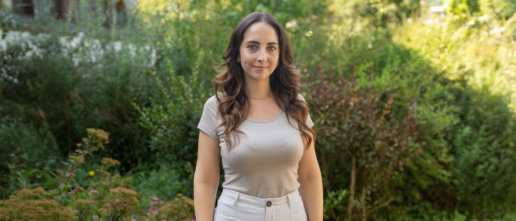 Yessica Silva vor einem grün bepflanzten Hintergrund