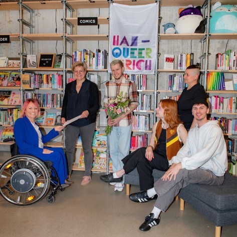 Mirjam Gasser übergibt der HAZ das Gratulationsschreiben der Stadt Zürich zur Verleihung des Gleichstellungspreises in der Regenbogenbibliothek 