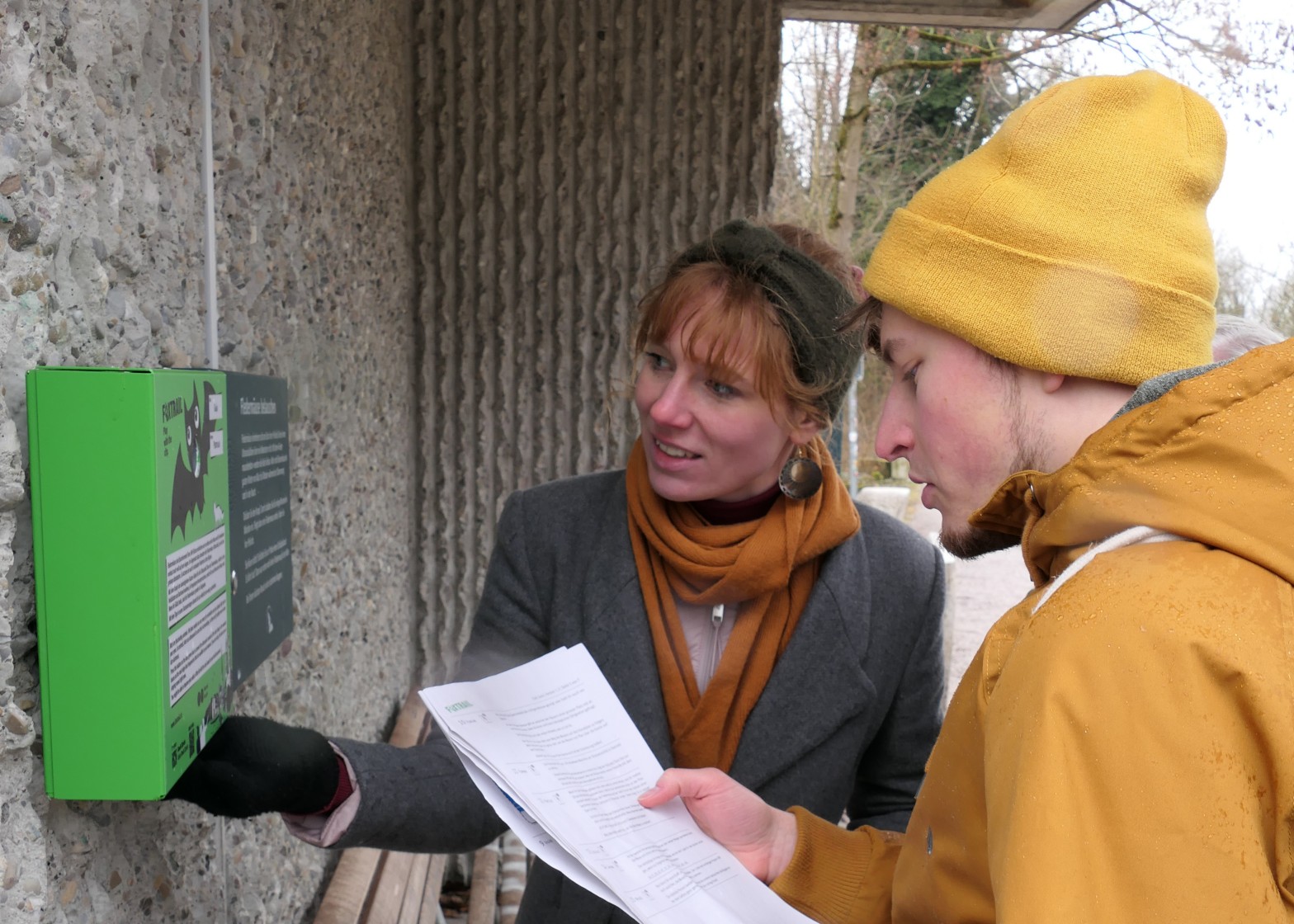 Eine Frau und ein Mann, die an einem Foxtrail-Posten stehen und rätseln. 