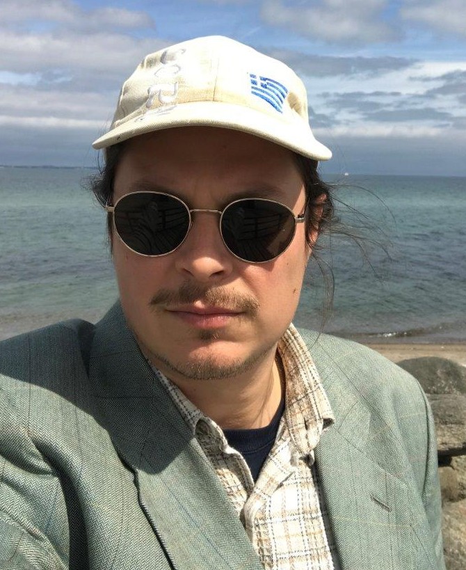 Das Bild zeigt ein Selfie-Foto von Benedikt Bock am Strand. 