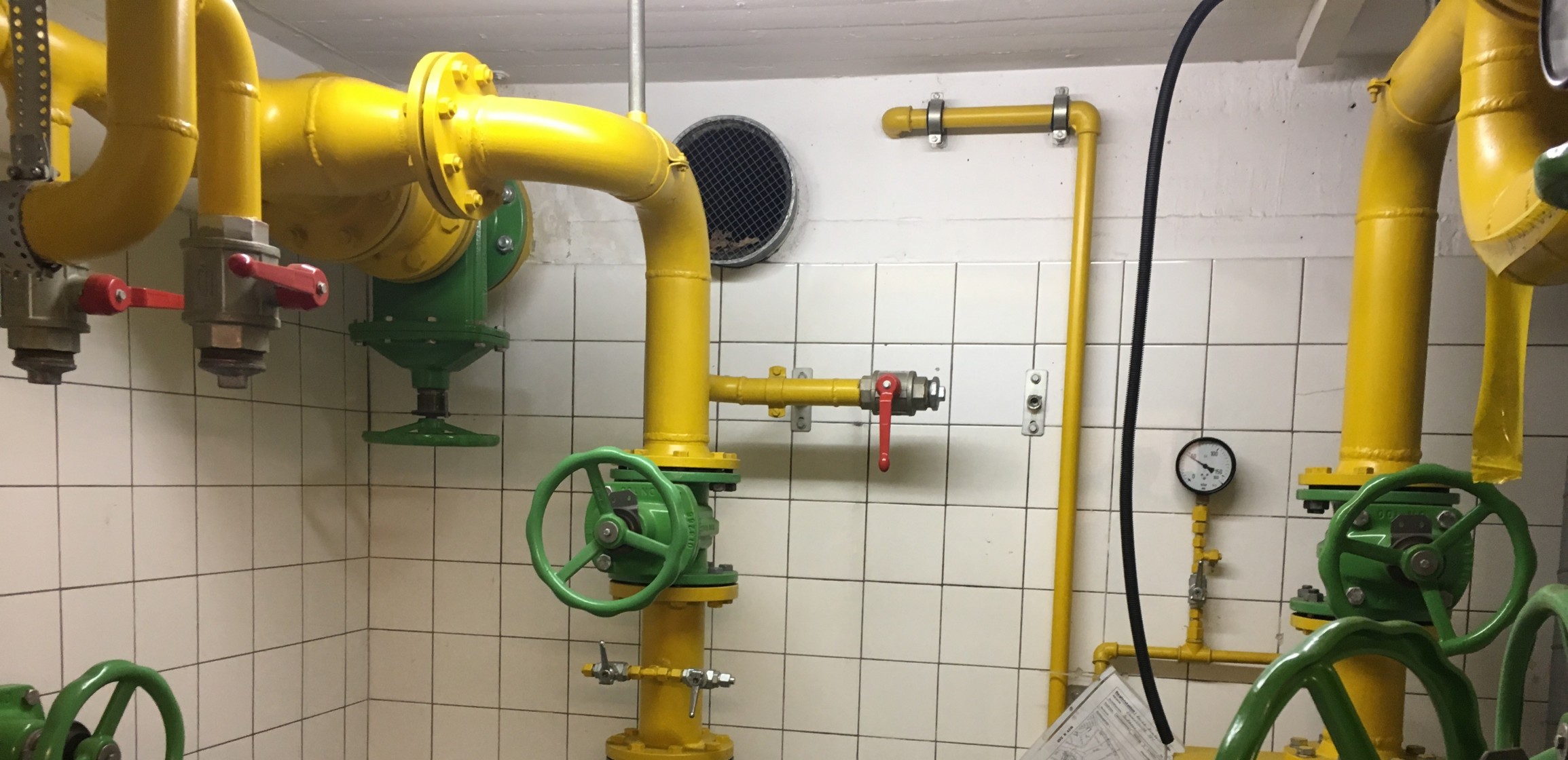 Gelbe Gasleitungen mit grünen Drehventilen