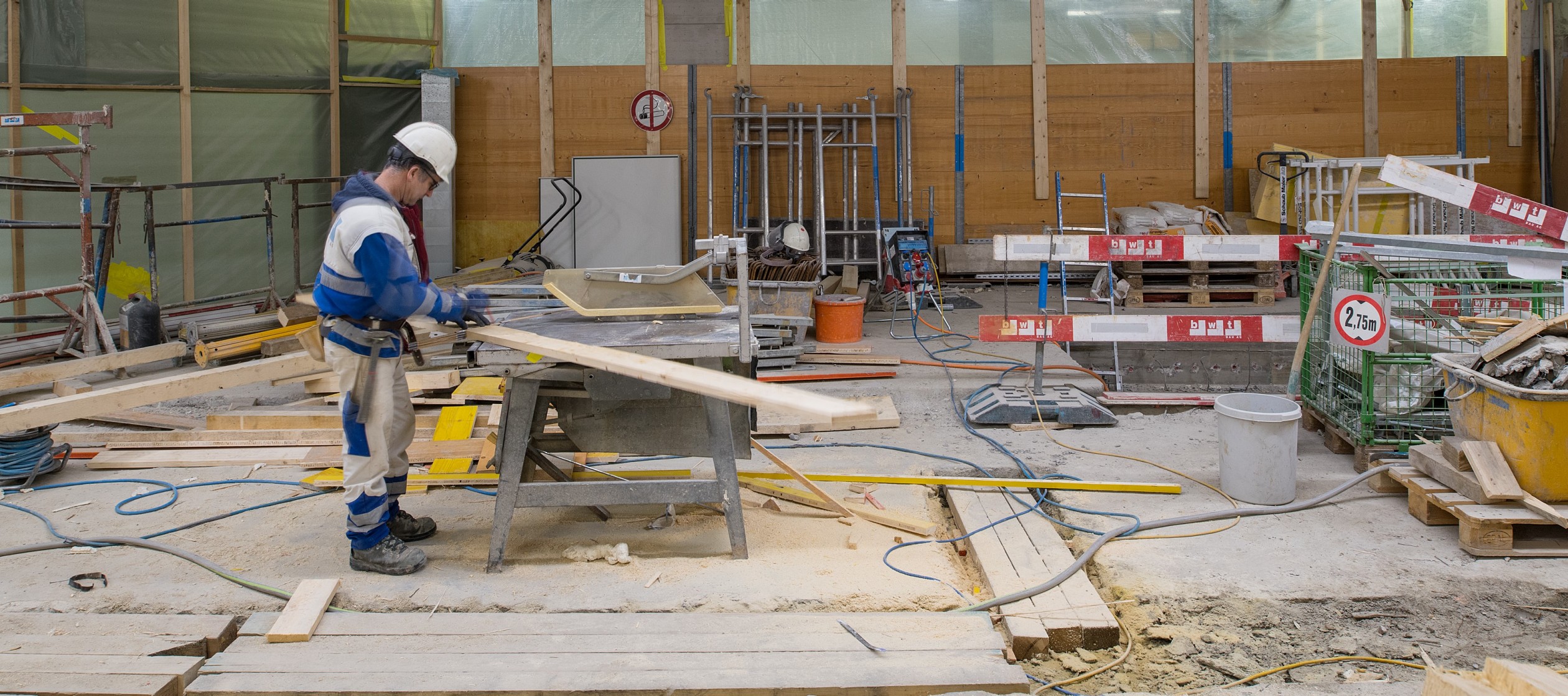 Bauarbeiter auf Baustelle arbeitet mit Holz