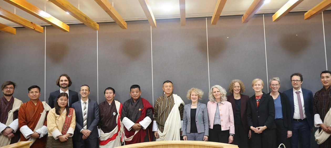 Aufgereiht in einem Raum stehen die Vetreter*innen aus Zürich und jene aus Bhutan. Diese sind traditionell gekleidet. 
