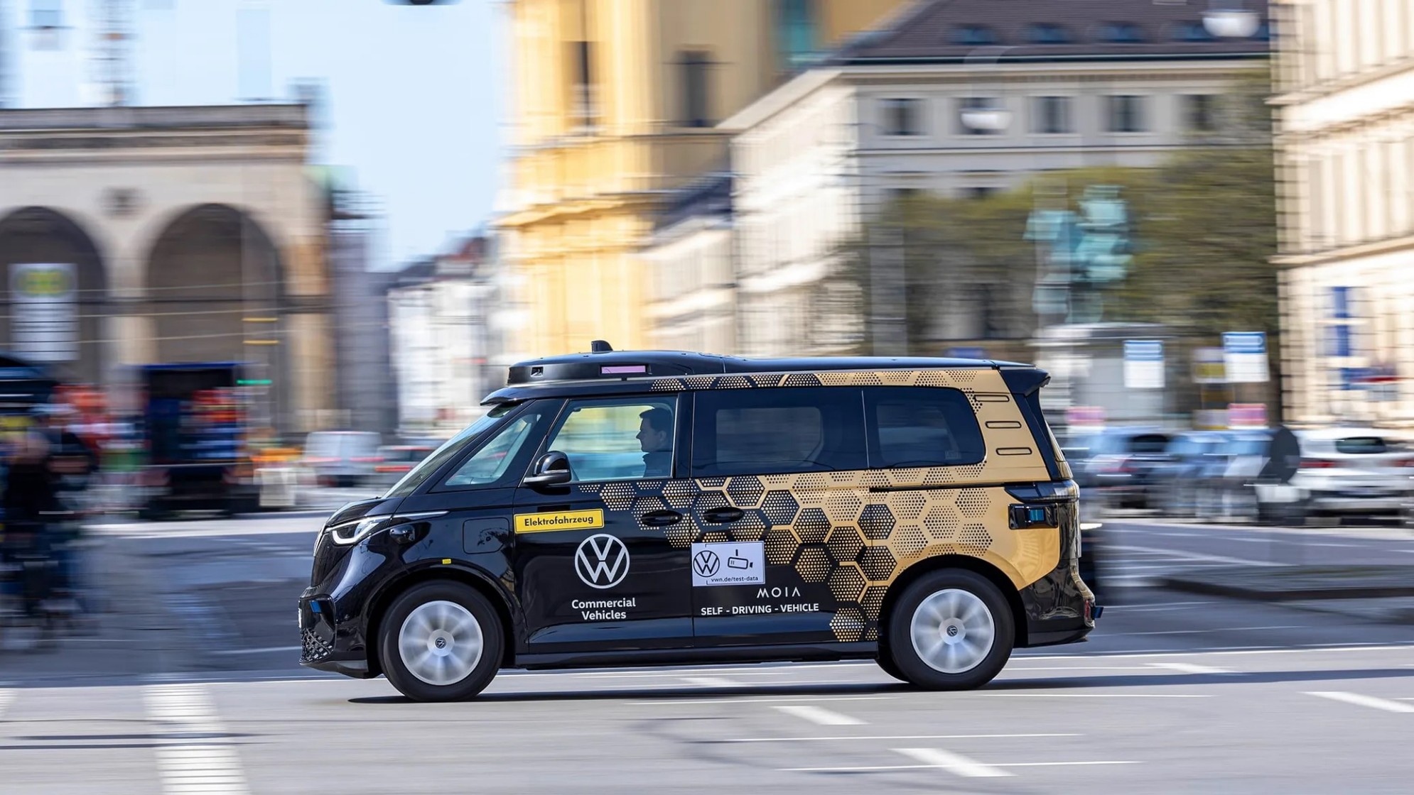 Ein kleiner Autobus mit Bienenwabenmuster saust durch die Stadt.