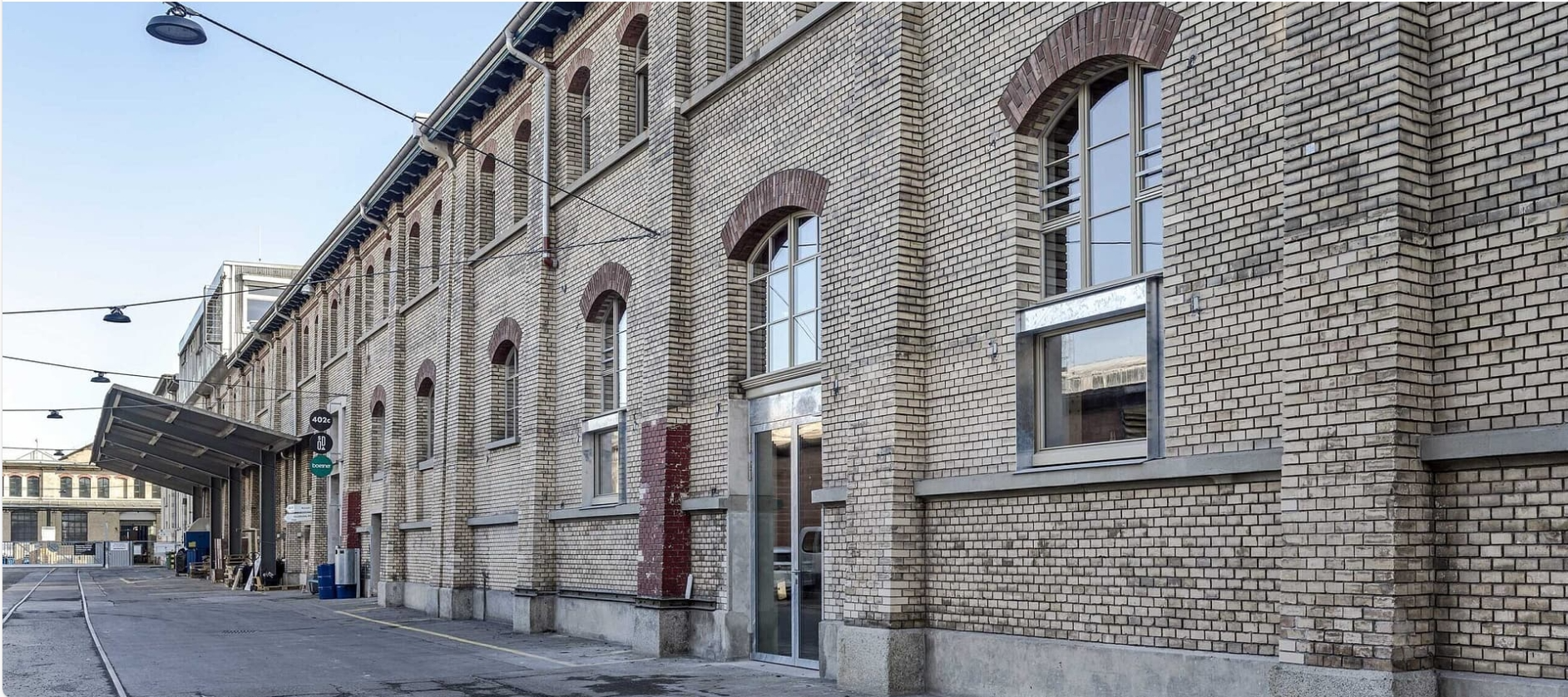 Die ehemaligen SBB Werkstätte in Alstetten. Auf dem Bild eine langgezogene historische Backsteinfassade .