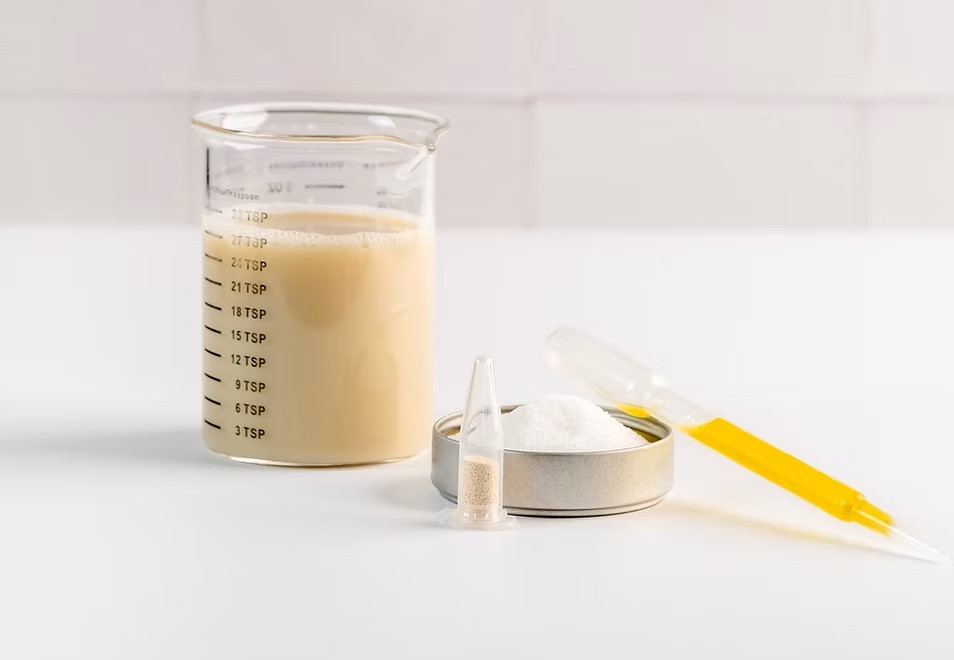 In einem Messglas sieht man eine milchige Flüssigkeit, daneben eine Pipette.