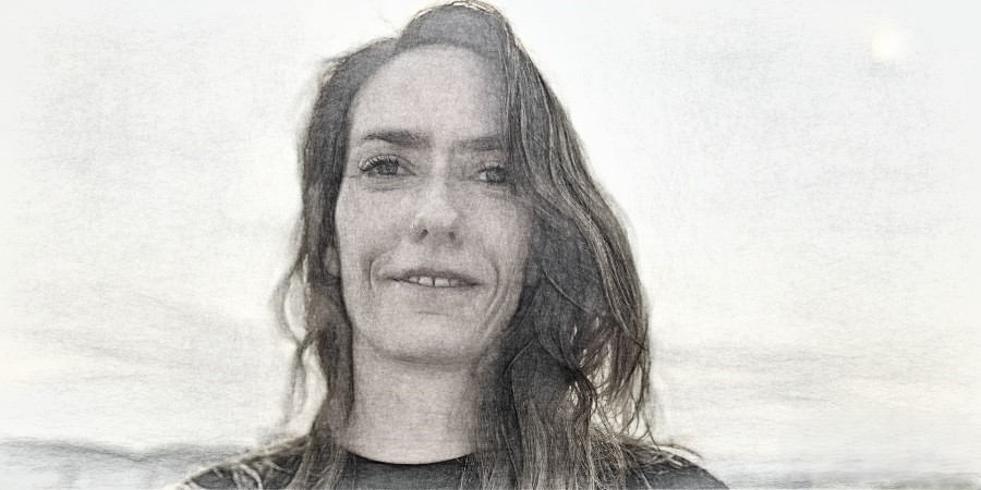 Ein Porträt von Nadine  Grätzer, eine junge Frau mit langen Haaren, blickt direkt in die Kamera.