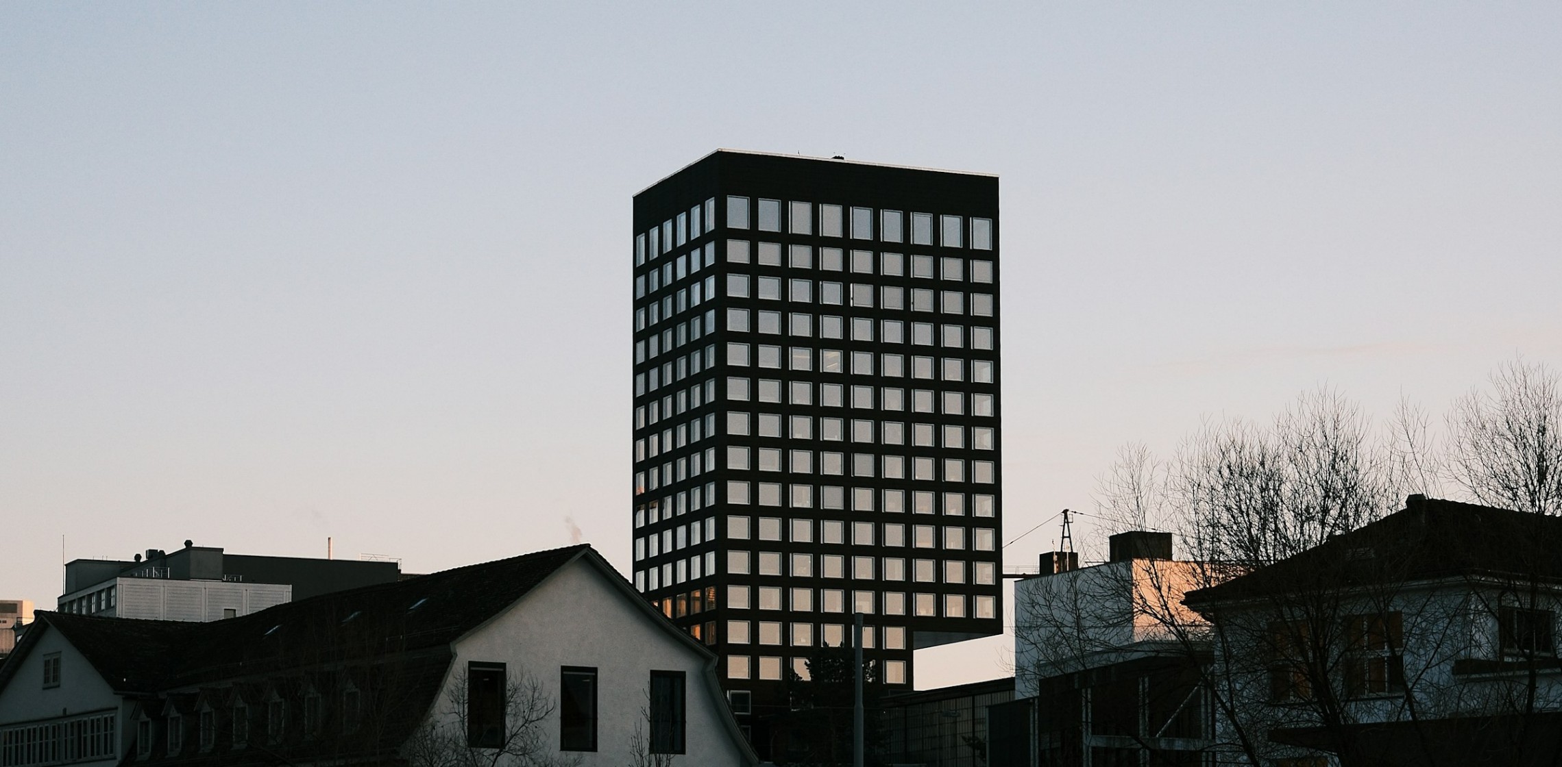 Hochhaus im Hintergrund mit tieferen Wohnhäuser im Vordergrund