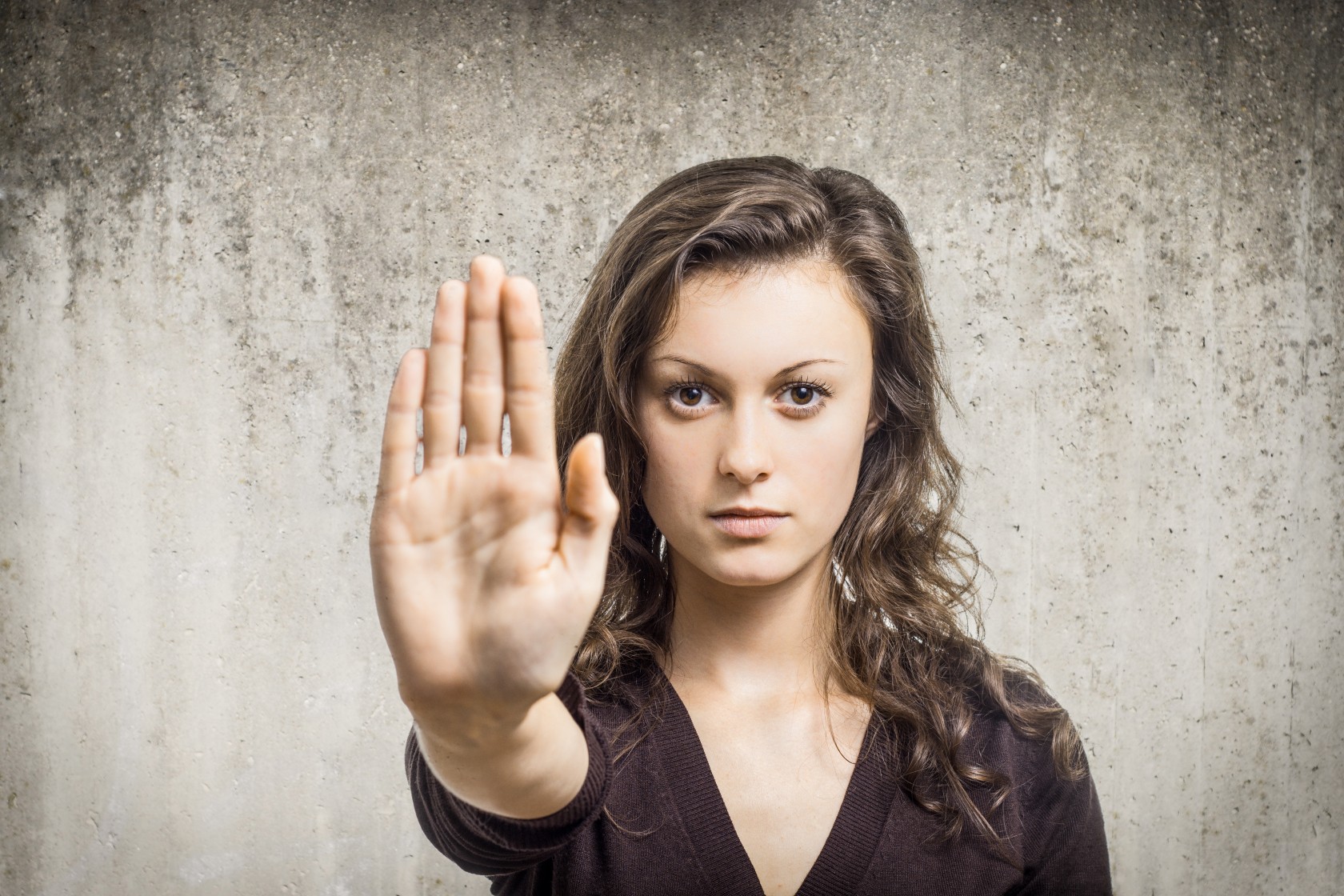 Eine Frau signalisiert mit der rechten Hand ein klares Stoppsignal