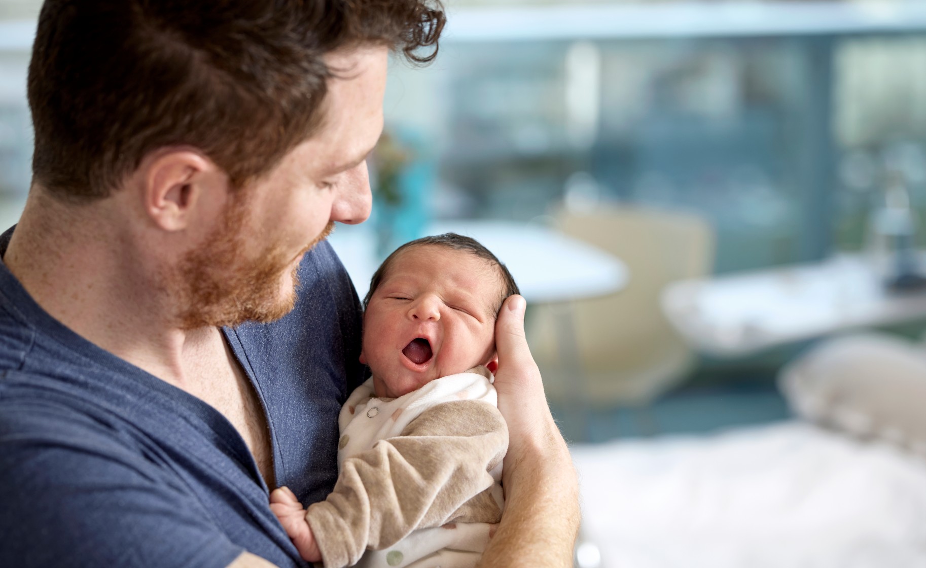Vater mit neugeborenem Baby in der Hand