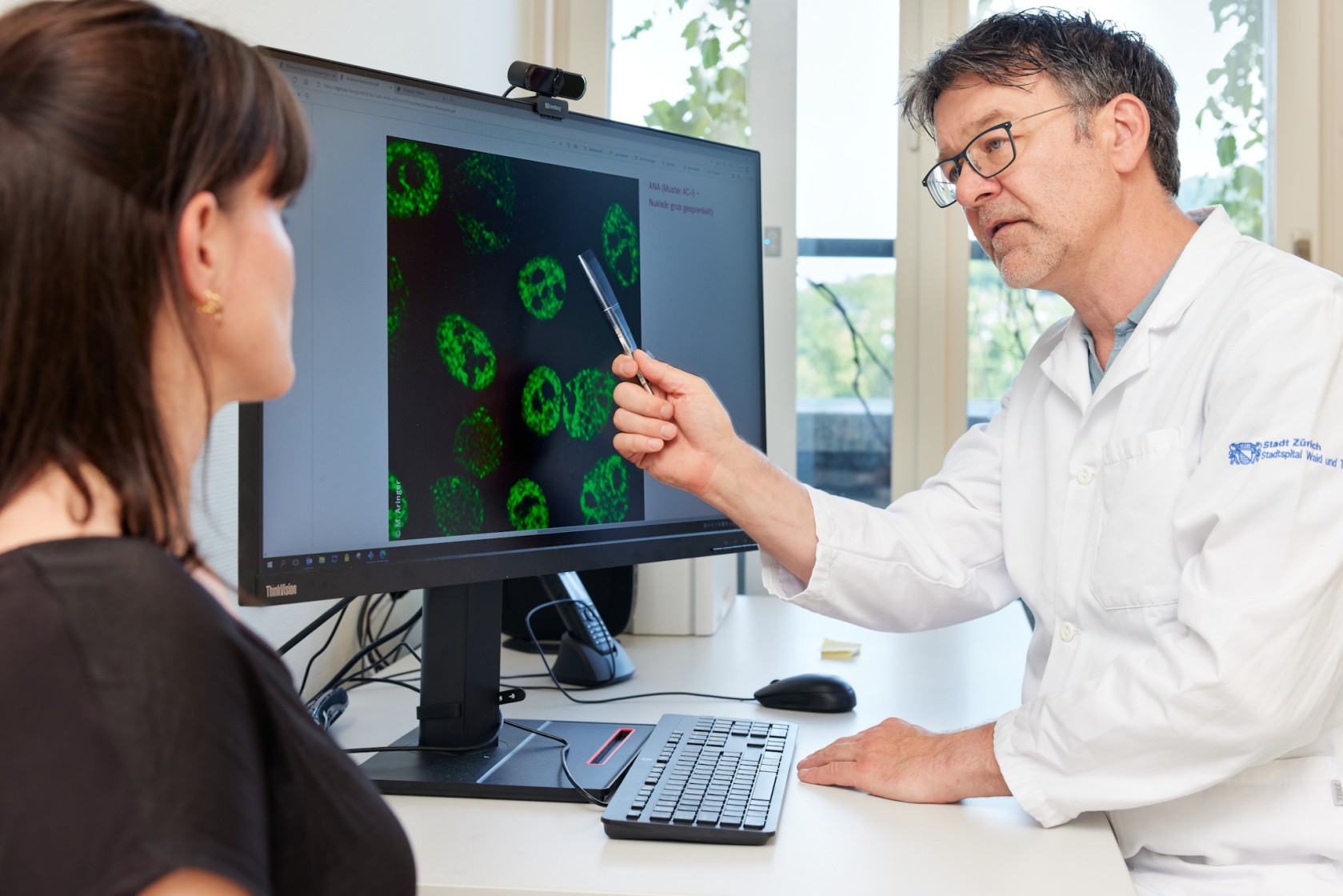 Arzt konsultiert Patientin vor dem PC