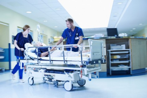 Two medics rushing with gurney in hospital emergency room