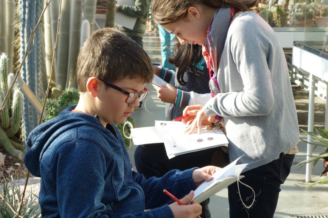 Teenagers in the show area filling out botanical questions.