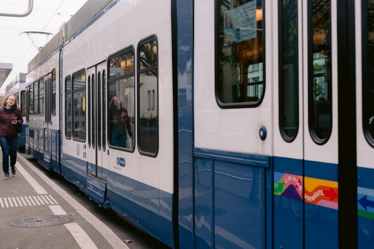 Eine blau-weiße Tram 2000 mit einer Sänfte steht auf einer Straße in einer städtischen Umgebung.