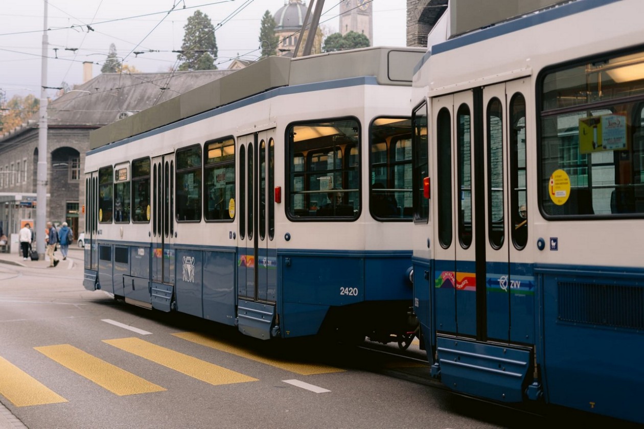 Eine blau-weiße Tram der Linie 10 steht an einer Haltestelle in einer städtischen Umgebung.