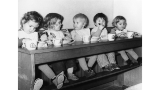 1956, Kinder geniessen eine Zwischenmahlzeit auf der Sitzbank in der Kinderkrippe Neustadtgasse der Stiftung GFZ (Quelle: Sozialarchiv)