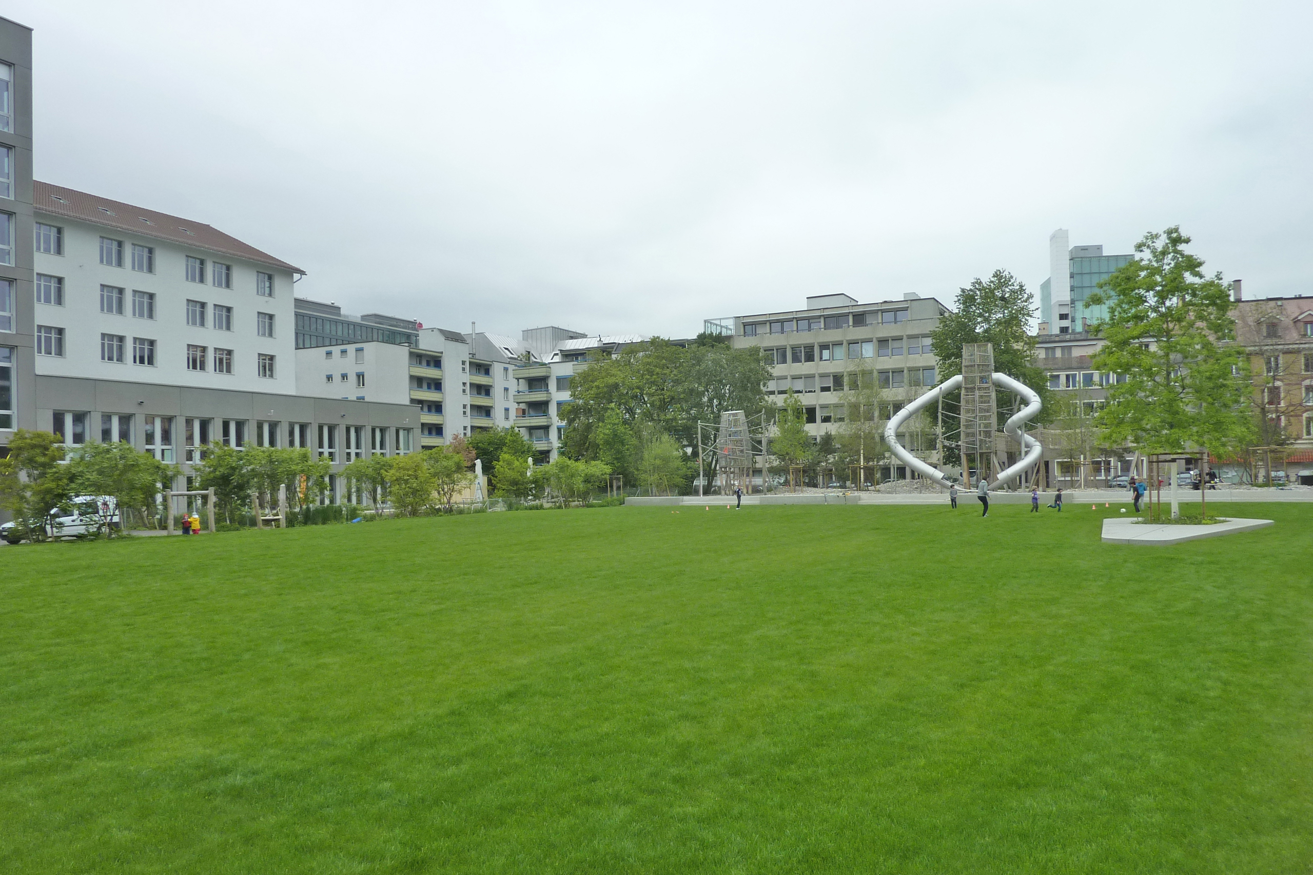 Bild, auf dem die Parkanlage zu sehen ist, mit Rasen und Spielplatz