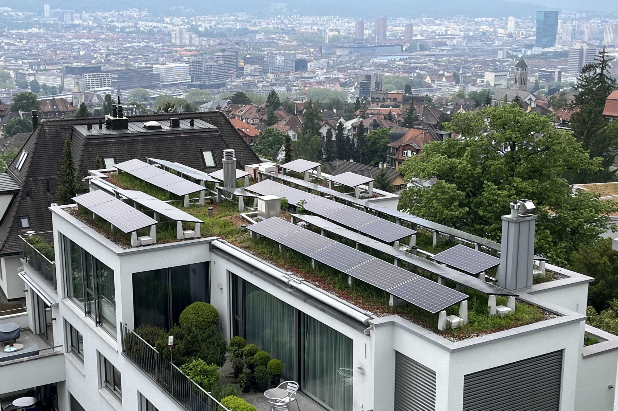 Blick von oben auf ein Solargründach eines Mehrfamilienhauses mit Attika