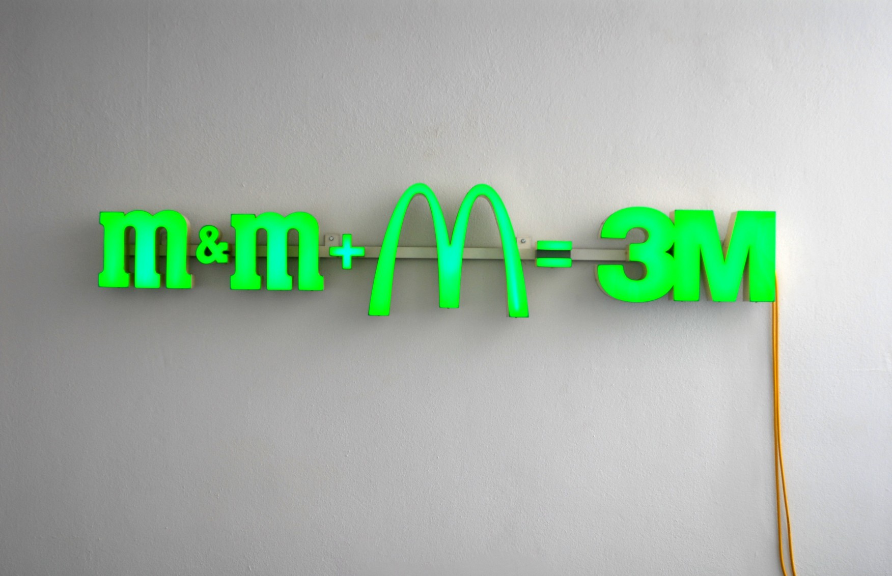 Die gleichung m&m + M = 3M als grüne Neonschrift