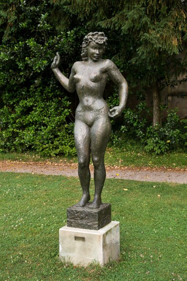 Bronzefigur eines stehenden Mädchens.