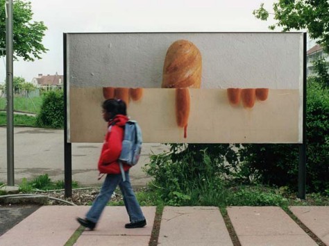 Plakat mit Foto, halbiert horizontal, oben ein halber Brotlaib unten andere Brote wie Finger angeordnet