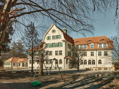 Kinderhaus Entlisberg Aussenansicht mit Pausenplatz im Vordergrund