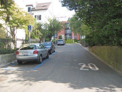 Begegnungszone Huttensteig. Mischverkehrsfläche auf gleichem Niveau ohne Kennzeichnung der Fahrbahn.