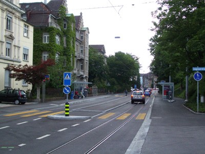 Weinbergstrasse. Haltestelle mit durchgehender Mittelinsel und Querung für Fussverkehr.