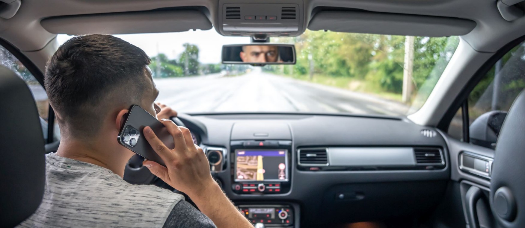 Businessman talking on cell phone while driving.