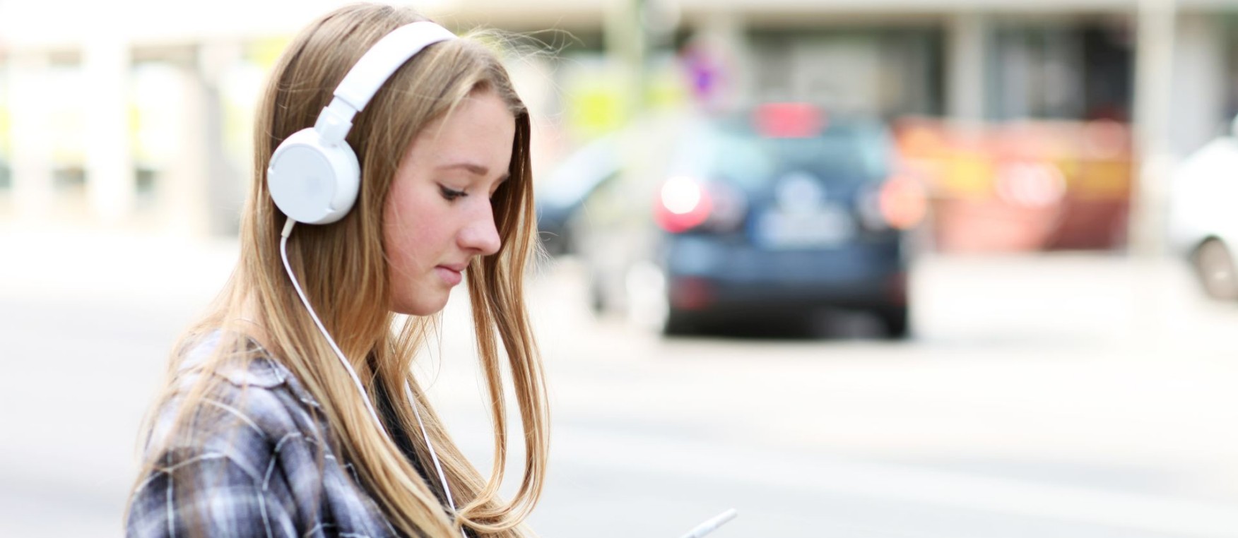 Teenager mit Handy und Kopfhörer im Verkehr