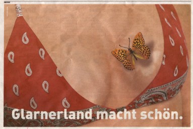 Dekolletee einer Frau mit Bikini-Oberteil im Glarnertüechli-Design. Ein Schmetterling flattert davon und einen nichtgebräunten Fleck. Der Text sagt: Glarnerland macht schön.