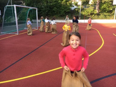 Verschiedene Kinder beim Sackhüpfen Verschiedene Kinder beim Sackhüpfen