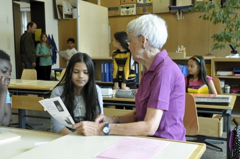Seniorin hilft Kindern beim Lernen