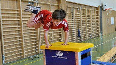 Junge beim Sprung über den Schwedenkasten im Sport