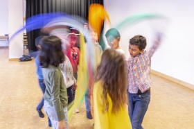 Kinder tanzend im Musikunterricht