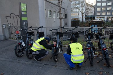 Zwei Männer kontrollieren ein Velo des Verleihsystems Publi-Bike.