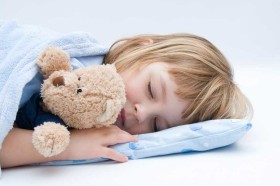 Mädchen schläft mit Teddybär