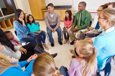 Kinder und Eltern an einer Multifamiliengruppen-Sitzung im Gespräch