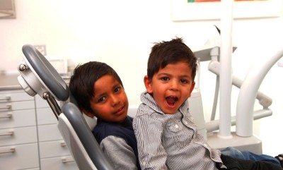 Zwei Kinder auf einem Behandlungsstuhl