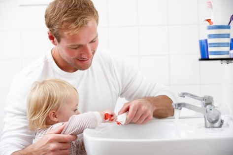 Vater putzt Kind die Zähne