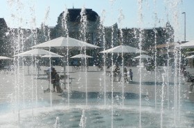 Das Bild zeigt das Wasserspiel auf dem Sechseläutenplatz bei sehr heissem Wetter. Im Hintergrund das Opernhaus. 
