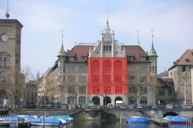 Megaposter am Stadthaus mit weisser Schrift auf rotem Hintergrund